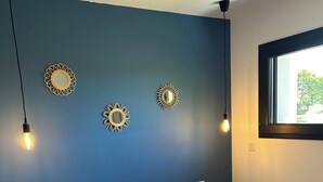 A bedroom with a bed, two bedside tables, a nightstand, and a window. - Bright house (Pornic)