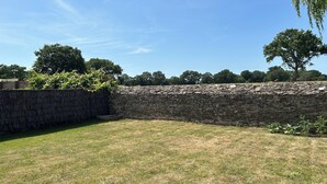 A stone wall with a grassy area in front. - Bright house (Pornic)