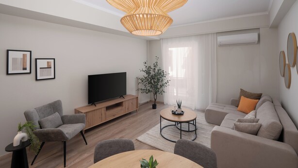 A modern living room with a flat-screen TV, grey sofas, a wooden coffee table, and a large wicker chandelier. - Spacious Luxury Apartment | Near Piraeus Port (Piraeus)