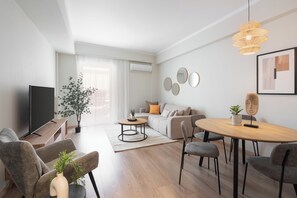 Apartamento superior, 2 quartos, sacada, vista para a cidade | Área de estar | TV 50 polegadas com canais a cabo