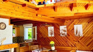 Un interior de madera con comedor, cocina y chimenea.