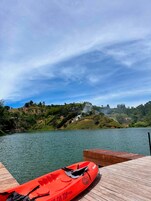 A wooden dock with a red kayak and a paddleboard.