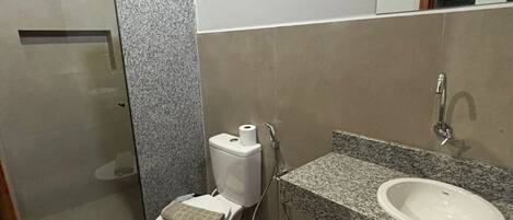 Un baño con inodoro, ducha y lavamanos.