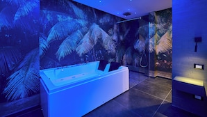 Un bagno moderno con una vasca da bagno ampia, un murale con palme e un design elegante.