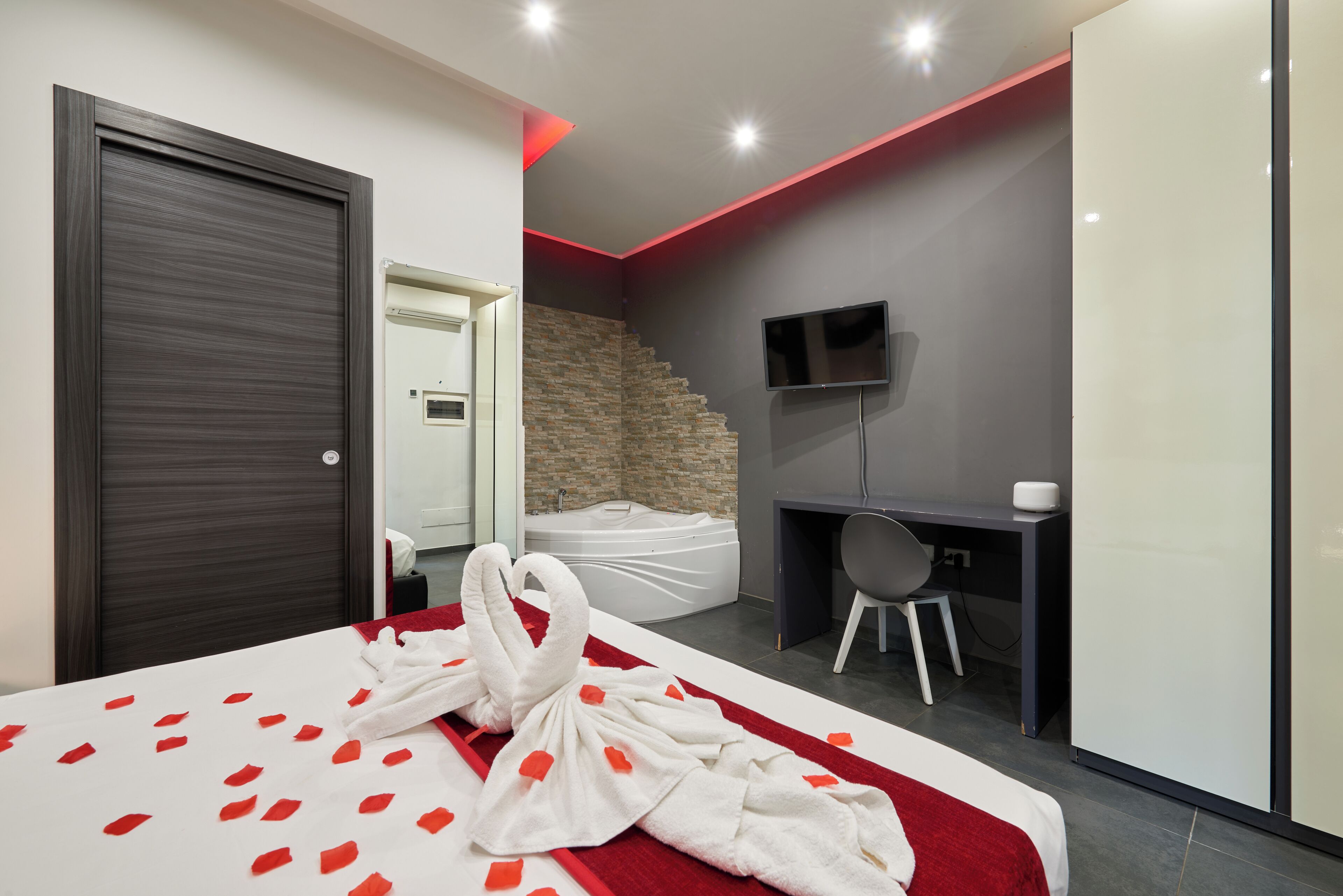 Une chambre d’hôtel moderne équipée d’un lit, d’un bureau, d’une télévision et d’un escalier.