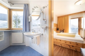 Une salle de bain avec un lavabo, un miroir et une douche.