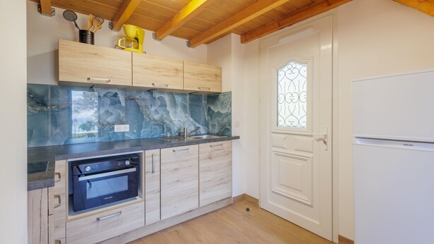 Una cocina moderna con armarios de madera, horno empotrado y refrigerador blanco.