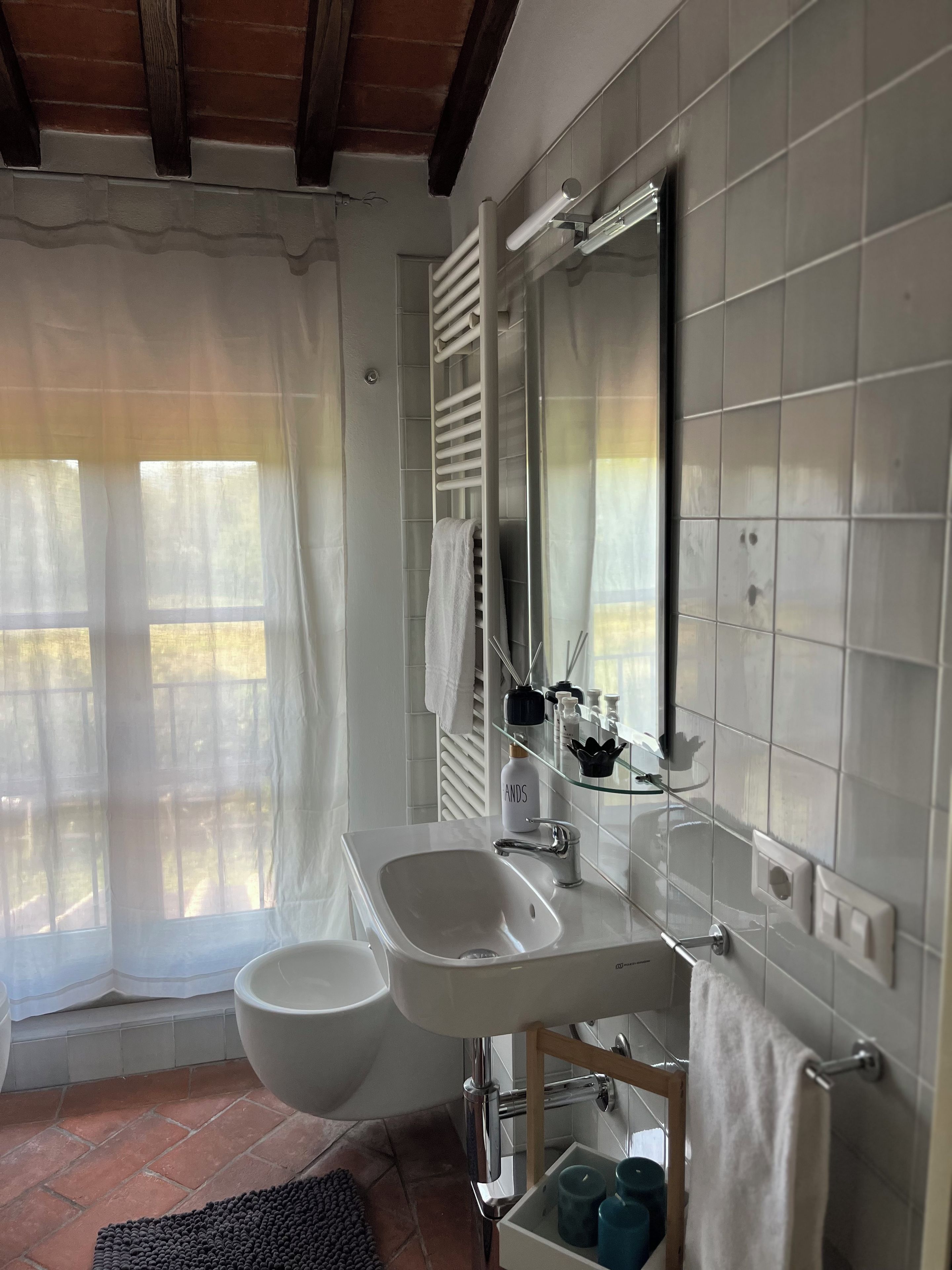 A bathroom with a white sink, a large mirror, and a bathtub.