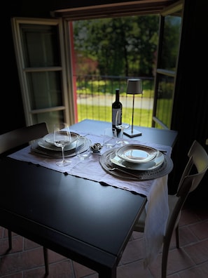 A table set for two with wine glasses, a bottle, and a lamp.
