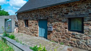 A stone building with a blue door, a window, and a mailbox. - La Jasserie - Jardin de 1800 m² et terrasse (Argol)