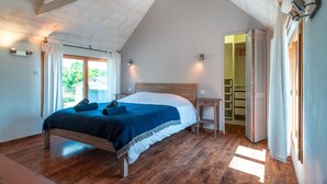 A bedroom with a wooden bed, a nightstand, a built-in shelf, and a window with curtains. - La Jasserie - Jardin de 1800 m² et terrasse (Argol)