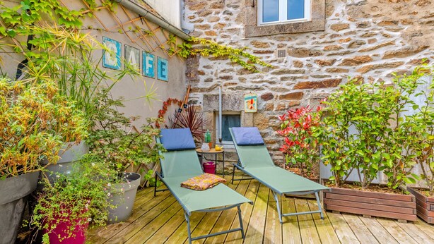 A wooden deck with two green lounge chairs and a small table with a cushion. - Ti Riboul - proche plage (Douarnenez)