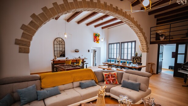 Ein geräumiges Wohnzimmer mit einer großen Couch, einem Couchtisch und einem Essbereich mit einem Klavier.