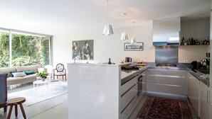 A modern kitchen with a central island, stainless steel appliances, and pendant lighting.
