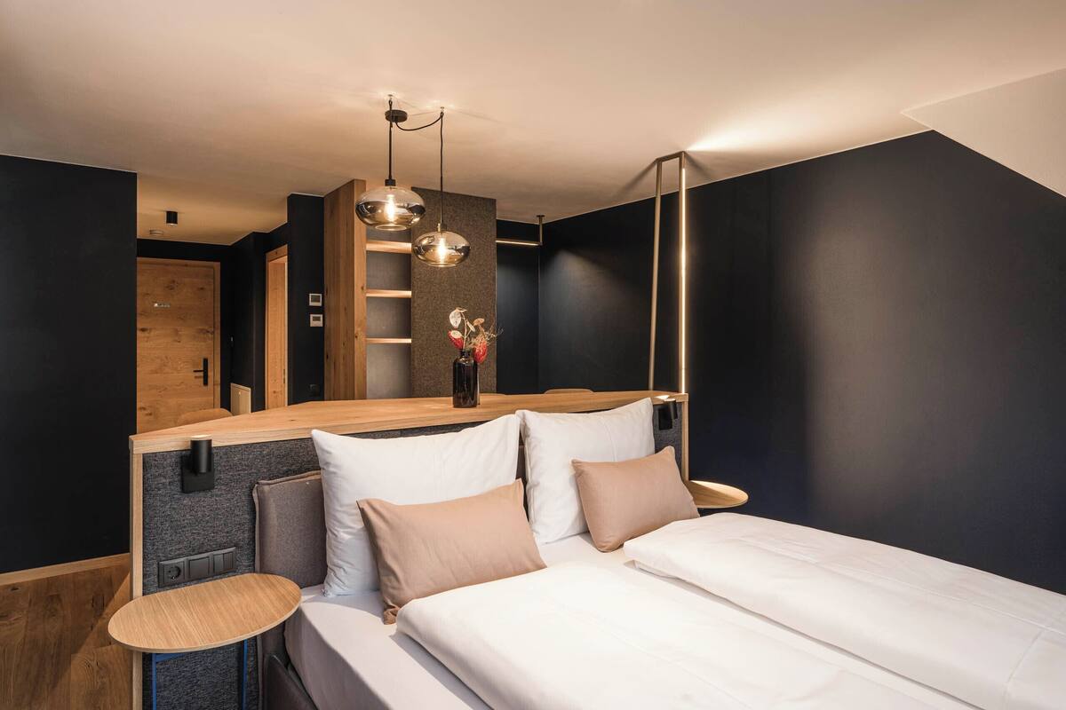 Ein modernes Schlafzimmer mit Bett, Nachttischen und einem Holz-Kopfteil.