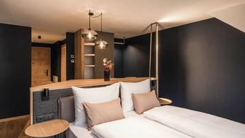 A modern bedroom with a bed, bedside tables, and a wooden headboard.