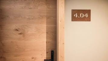 Een houten deur met een metalen handvat en een bord erboven met de tekst '4.04'.