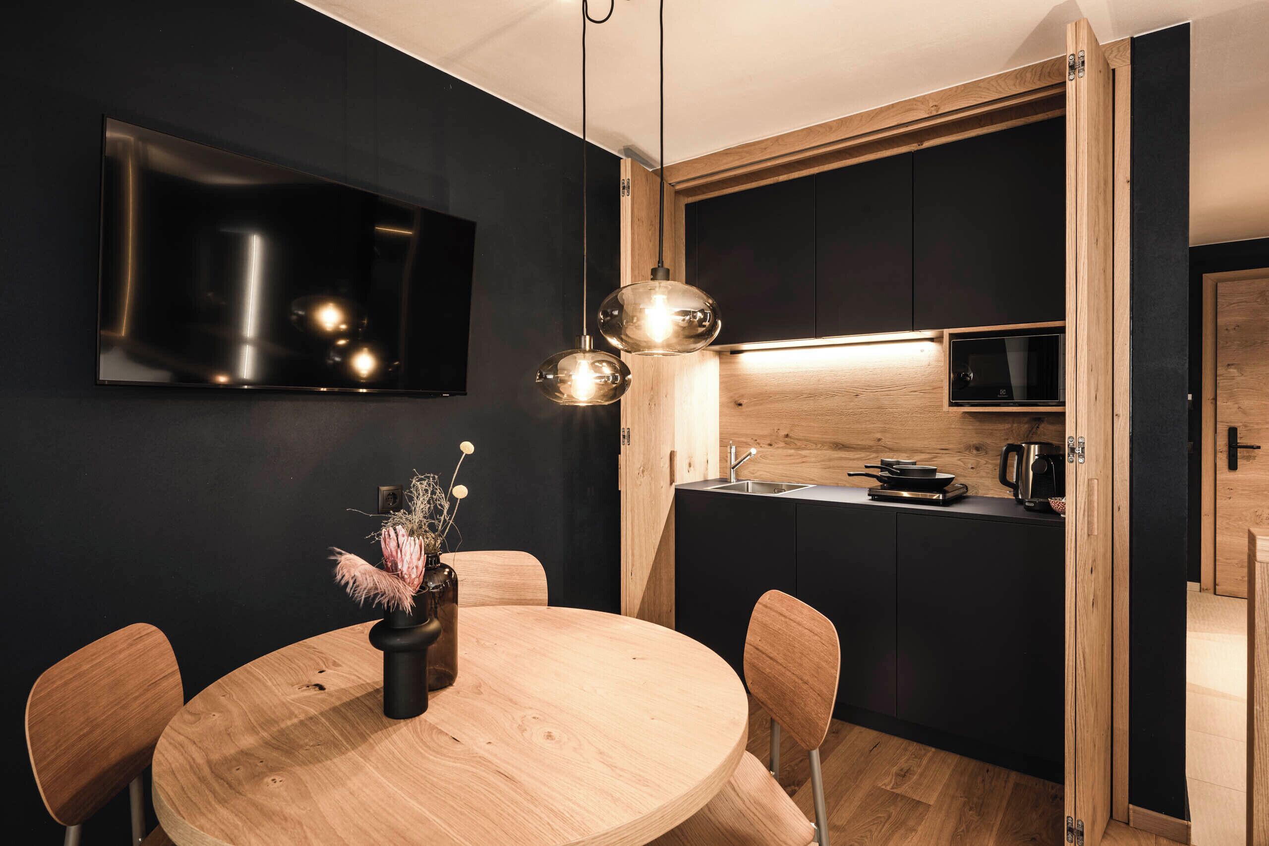 A modern kitchen with a wooden countertop, a built-in microwave, and a sink.