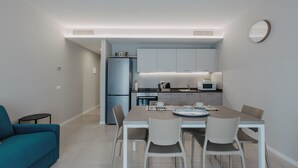 Una cocina moderna con comedor, un sofá y un reloj en la pared.