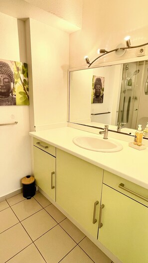 A bathroom with a sink, mirror, and a trash bin. - Sea, boat and mountain views, beach just around the corner! (Le Gosier)