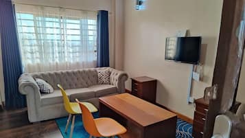 Comfort-Apartment, Stadtblick | Wohnbereich | 24-Zoll-Smart-TV mit Digitalempfang