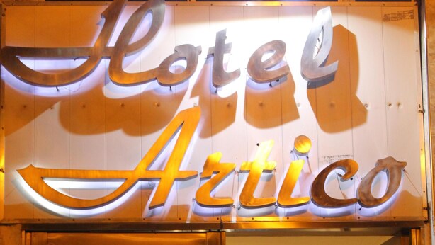 De ingang van een hotel, met een bord waarop staat 'Hotel Artico'.