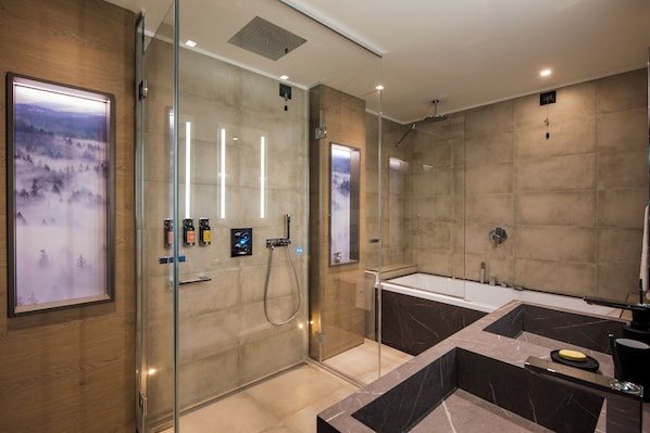 Een moderne badkamer met een douchecabine van glas, een vrijstaand bad en een grote spiegel.