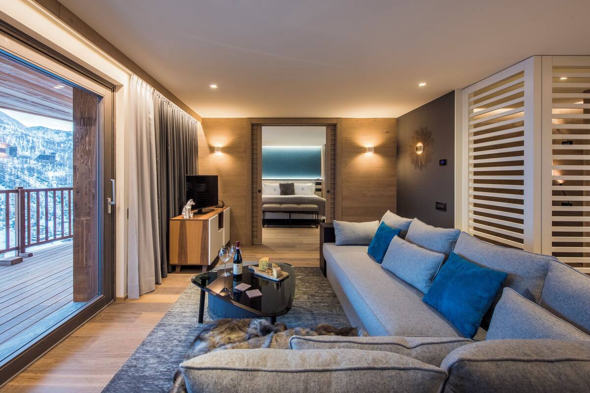 A modern living room with a sofa, coffee table, and a view of a balcony.
