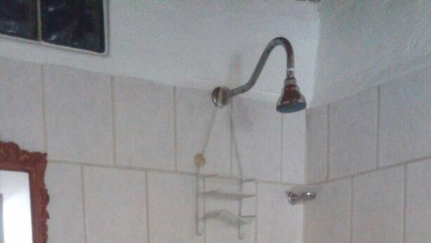 A bathroom with a shower, a sink, and a mirror.