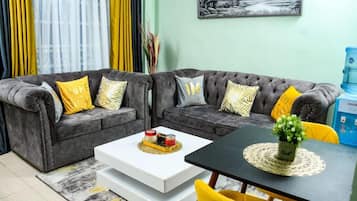 Deluxe-Apartment, Stadtblick | Wohnbereich | 24-Zoll-Smart-TV mit Digitalempfang