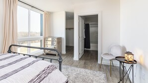 Ein Schlafzimmer mit einem Bett, einem Nachttisch mit einer Laterne, einem Sessel und einem Kleiderschrank.