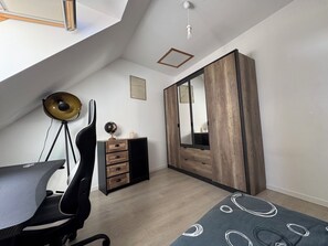 A modern bedroom with a desk, chair, dresser, and a large mirror. - Stone house near the sea (Tréméven)