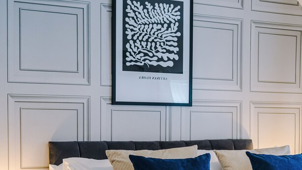 A neatly made bed with a dark headboard, white and striped pillows, and a blue blanket. - 3BR House w/ Parking, Free Wifi, and Discounts! (Droylsden)