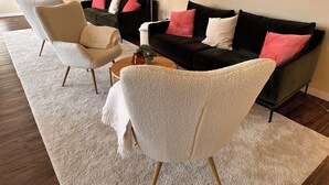 Un salon moderne avec deux canapés, une table basse et un fauteuil.