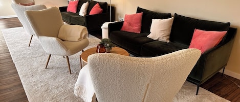 A modern living room with two sofas, a coffee table, and a chair.
