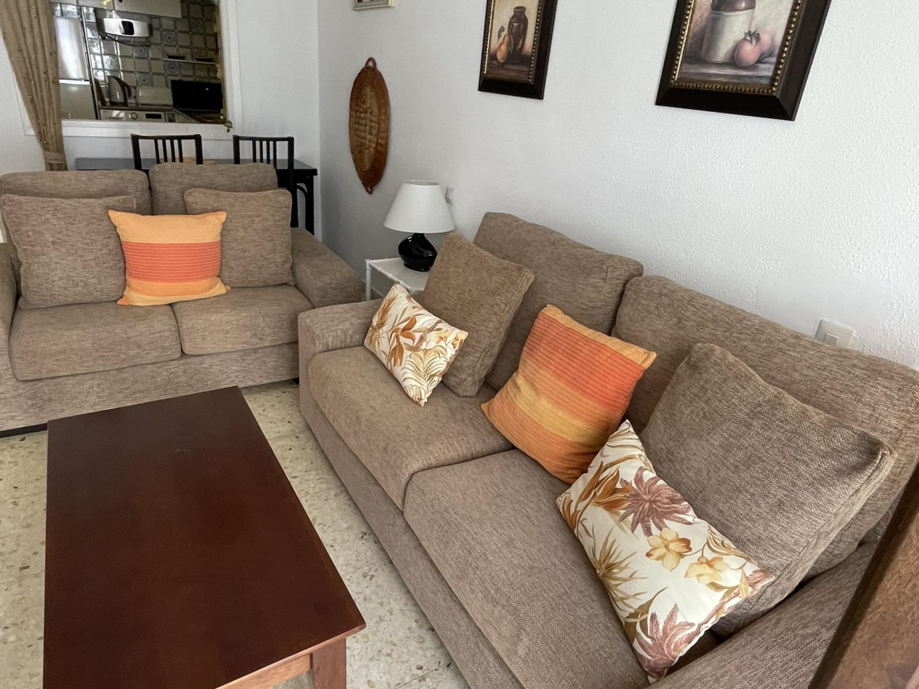 A living room with two sofas, a coffee table, and a lamp.