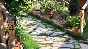 Un sendero de piedra que lleva a una estructura de madera con un cartel con el número 4.