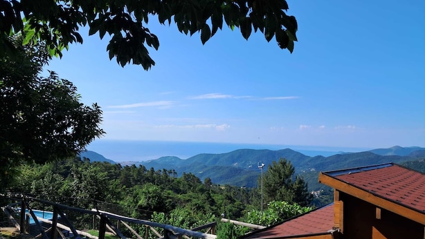Una cabaña de madera con techo rojo que domina un paisaje montañoso.