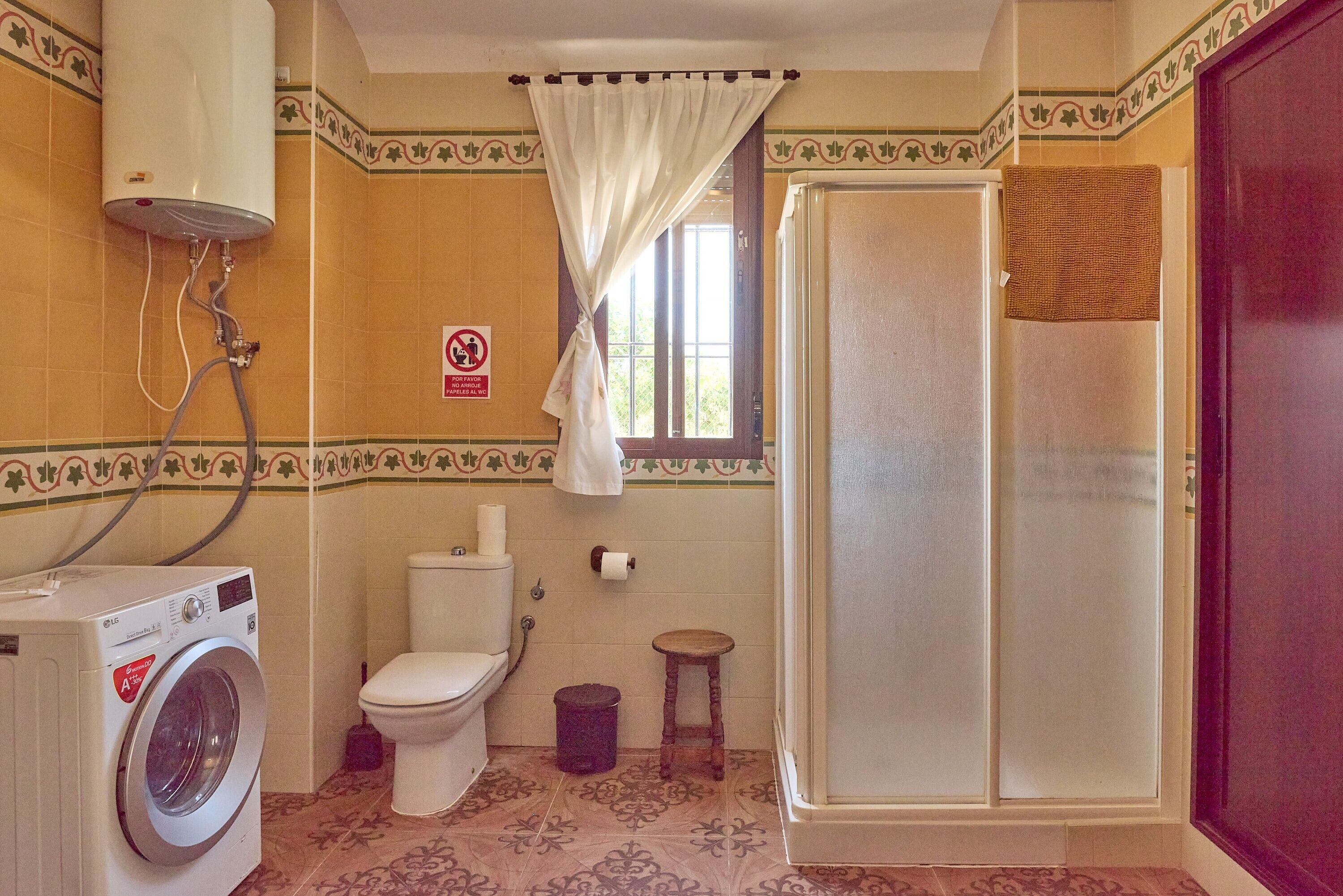 Un baño con lavadora, inodoro y ducha.