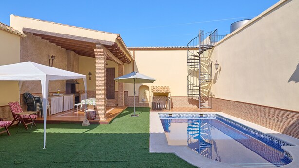 A backyard with a pool, artificial grass, outdoor furniture, and a covered patio area. - Santa Fe Rural Tourist Home with Private Pool, Wi-Fi & Air Conditioning (Montilla)