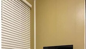 Een kamer met een open haard, een televisie op een standaard en een kamerbreed tapijt met een patroon.
