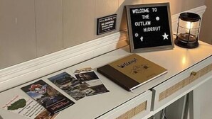 Een receptiebalie met een bord met daarop 'welkom', een klein bordje dat rookverbod aangeeft en een decoratieve lantaarn.