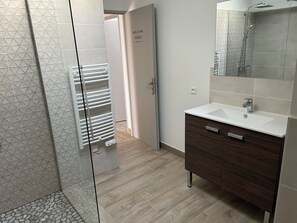 Een douche, een haardroger, handdoeken, toiletpapier