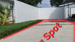 A concrete pathway with a red line marking, leading to a white fence. - Perfect Guest house/studio just 15mins drive to the beach for a relaxing getaway (West Park)