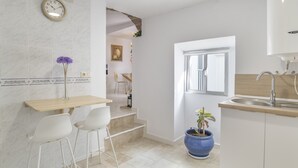 A modern kitchen with a sink, a clock, and a potted plant. - Country House 'El Rincón de Hugo' with Mountain View, Private Terrace, A/C and Wi-Fi (Alcalá De Los Gazules)