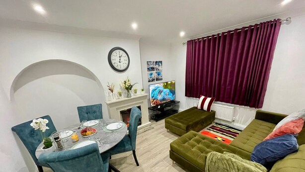 Ein modernes Wohnzimmer mit Essbereich, Kamin und Fernseher.