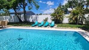 A swimming pool with clear blue water, surrounded by a white fence, and lined with blue lounge chairs. - 4-bedroom heated Pool house in lovely Osprey, 5 minutes to the beach (Osprey)