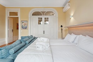 Une chambre d’hôtel avec un lit, un canapé, une affiche et une porte.