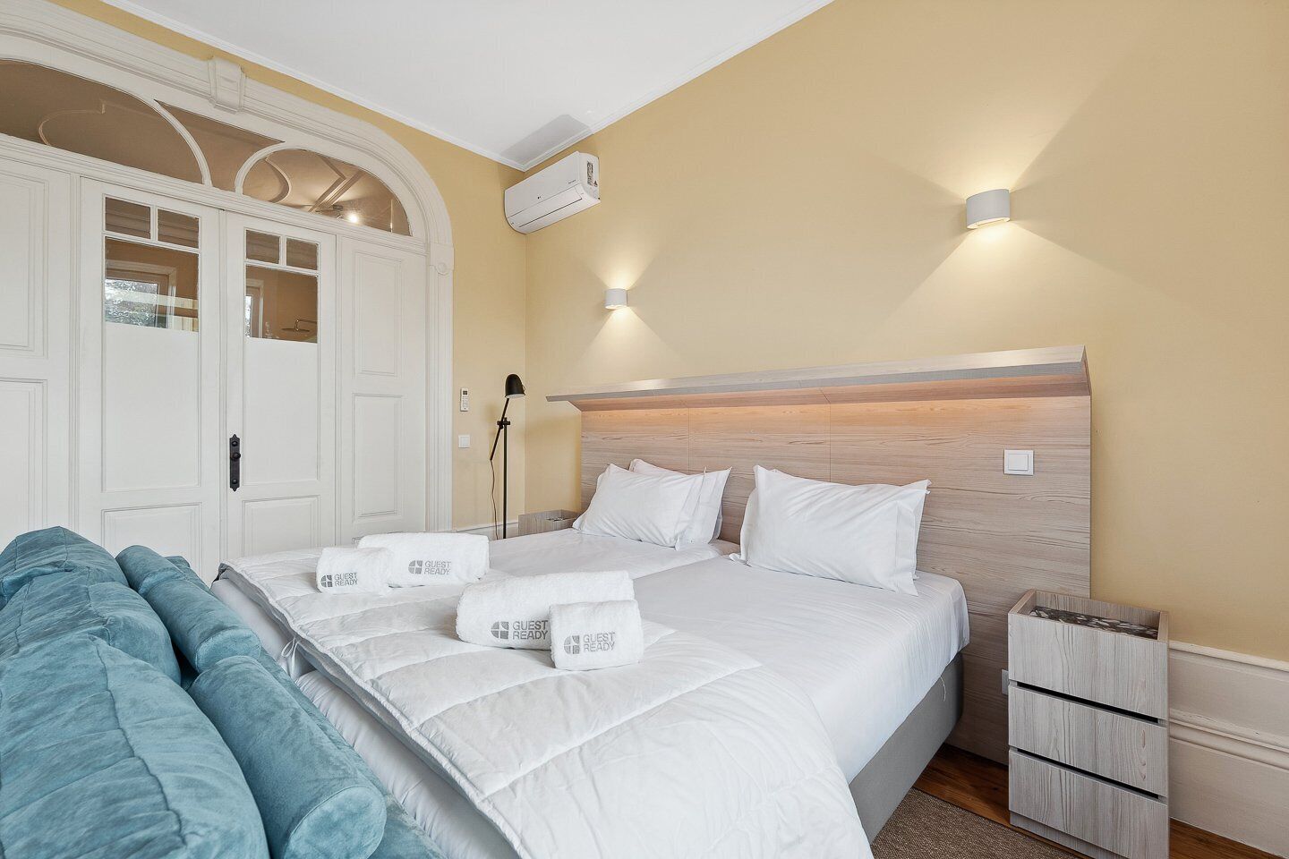 Ein Hotelzimmer mit einem großen Bett, einem Nachttisch, einer Lampe und einem Kleiderschrank.