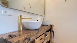 A bathroom with two white vessel sinks, a wooden vanity, a large mirror, and a gold faucet. - La Millière - "Marie-Anne & Marie-Adélaïde & Charette" - Chambres indépendantes - Piscine & campagne - (Le Poiré-sur-Vie)